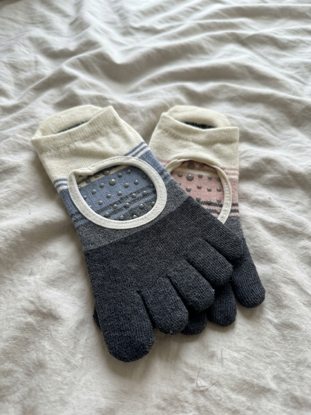 A customer photo shared by Kalley featuring YG Socks striped open-toe and open-back grip socks, showcasing the real textured knit and non-slip silicone dots on a white bedsheet.
