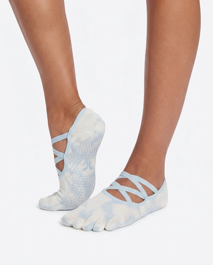 Side and back angle view of the Full Toe Cloud Wash Low Rise Grip Socks during a studio pose, highlighting the secure low-rise fit, cross straps, and grip soles.