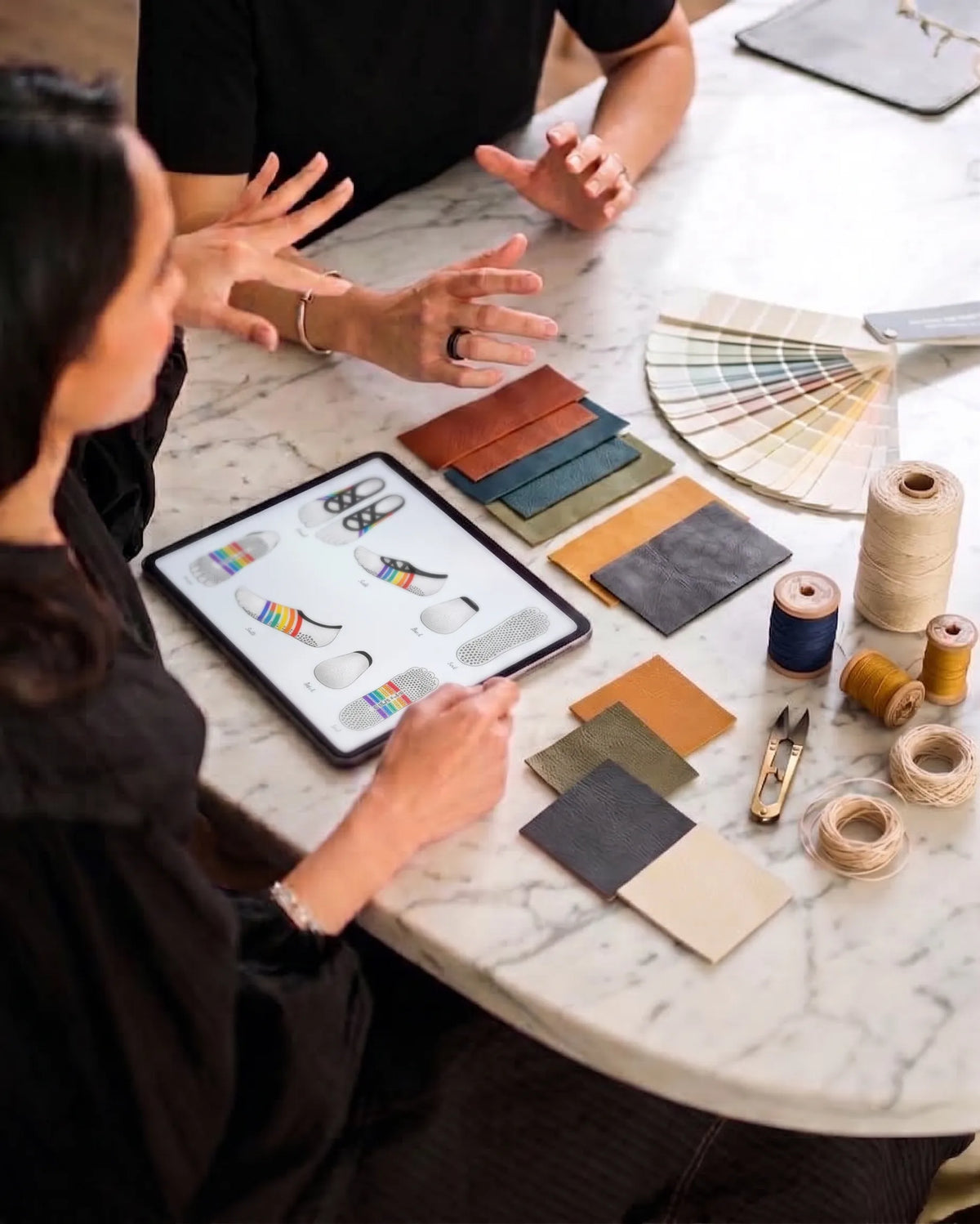Yanng design team reviewing five-toe grip sock sketches with material swatches and color palettes.